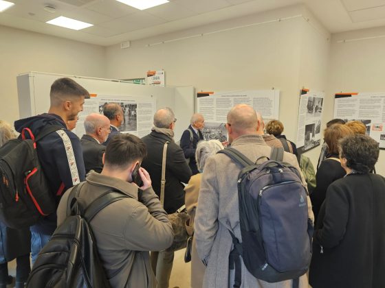gruppo di persone riprese di spalle che partecipano a un'inaugurazione di una mostra